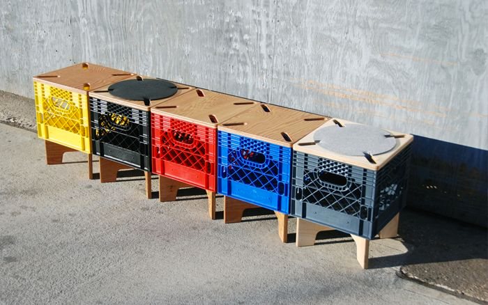 A bench made from a row of coloured milk crates with round cushioned tops
