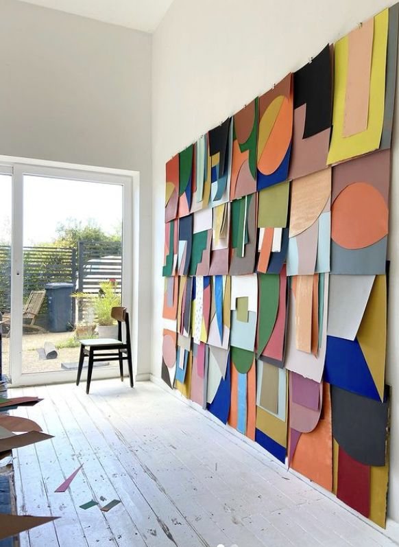 A wall of layered, colourful cut-out shapes