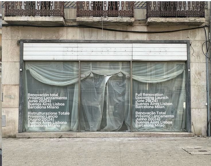 A shopfront veiled in translucent sheeting printed with text