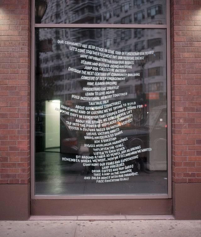 A shop window covered in flowing white vinyl text