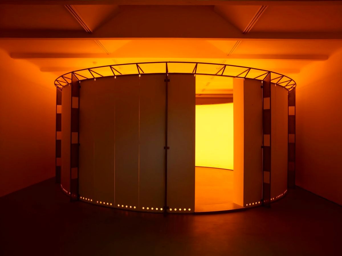 A circular curtained enclosure glowing amber from within, ringed with lights