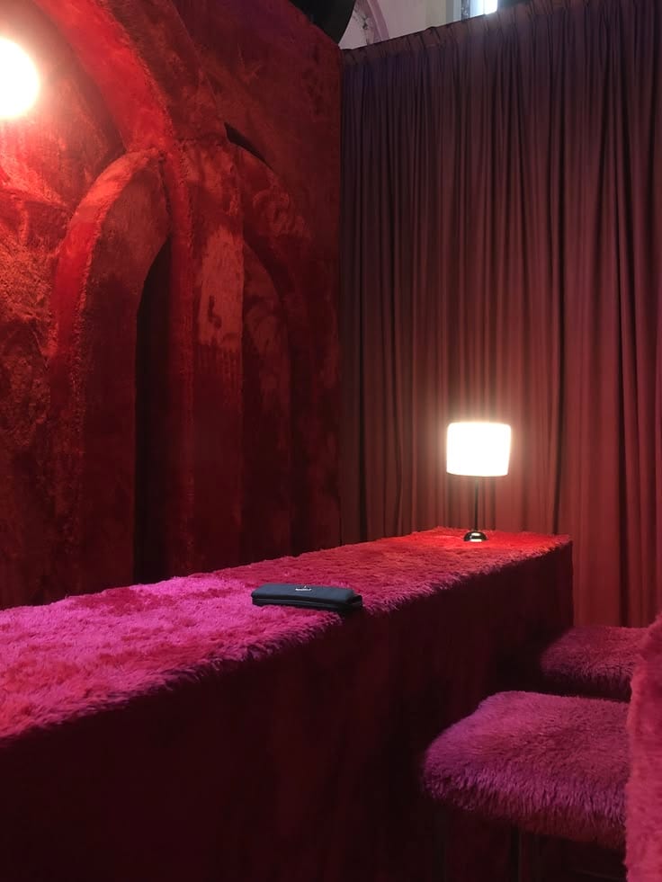 A deep pink snug lit by a single lamp