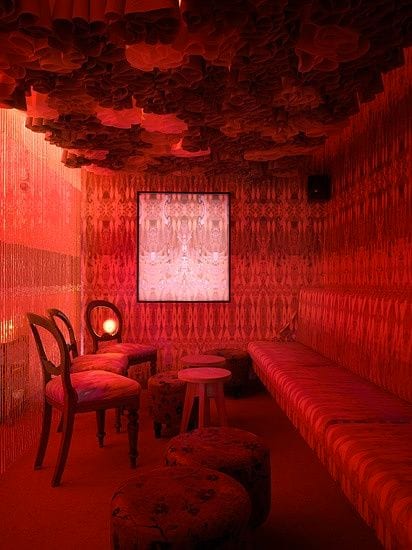 A red velvet room with a tufted ceiling